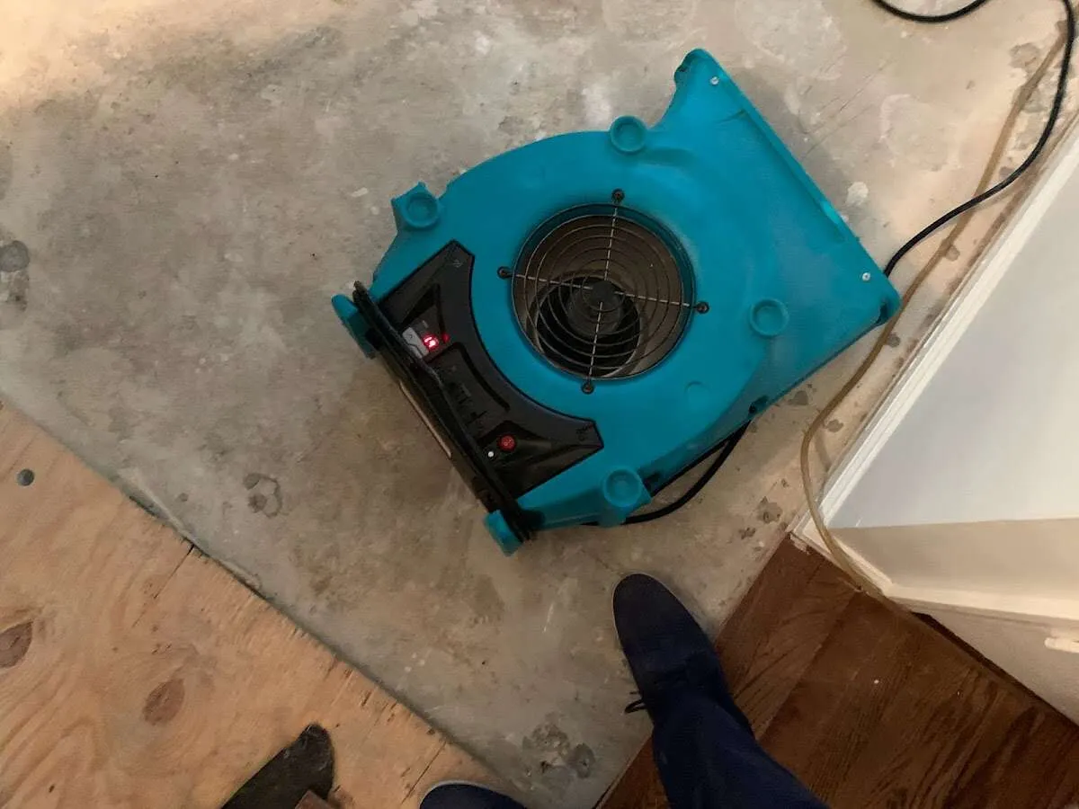Air mover drying subfloor during Commercial Water Damage Restoration in Adams